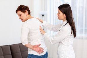 Orthopedic surgeon in Indore Dr. Tarkit Modi explaining lower back pain treatment options to a patient